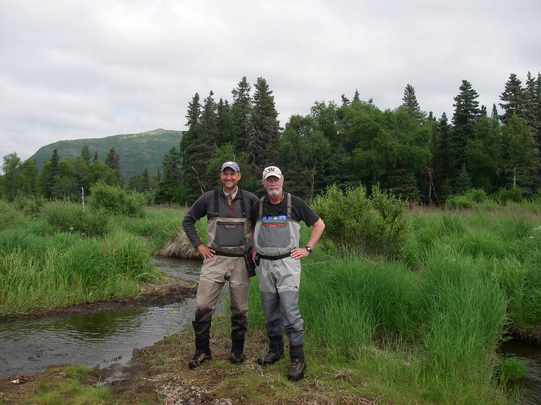 Aaron Wirsing and friend standing near stream in natural area