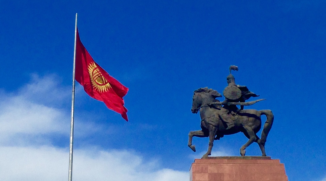 A military monument and flag against a blue sky