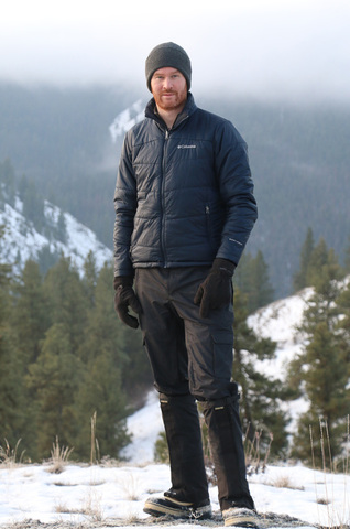 Thomas Newsome standing in a snowy mountain area with evergreen trees