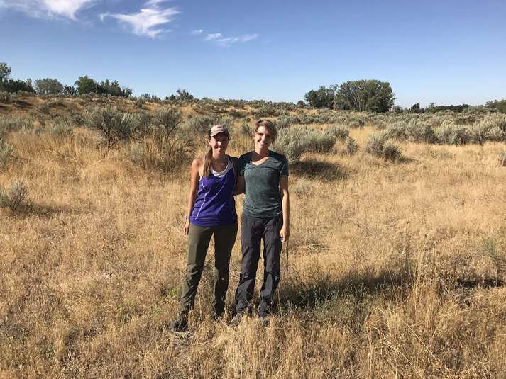 Photo of Erin Morrison and Emily Schafsteck standing in dry sunny area with sagebrush